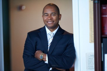 Photo of business law and civil litigation attorney Tom Douglas, standing and smiling, with arms crossed.